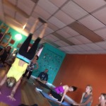 People practicing yoga indoors with one person doing a handstand.