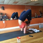 Person performing a yoga pose indoors on a mat.