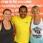 Three smiling people posing together in workout attire after yoga.