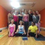 Group of people posing in a yoga studio.