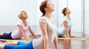 Three women practicing yoga indoors together.
