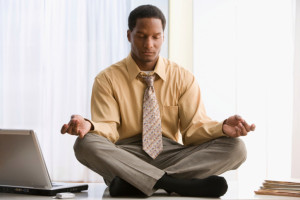 African American businessman meditating on desk