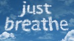 Clouds forming the words 'just breathe' against a blue sky. Clouds forming the words 'just breathe' against a blue sky.