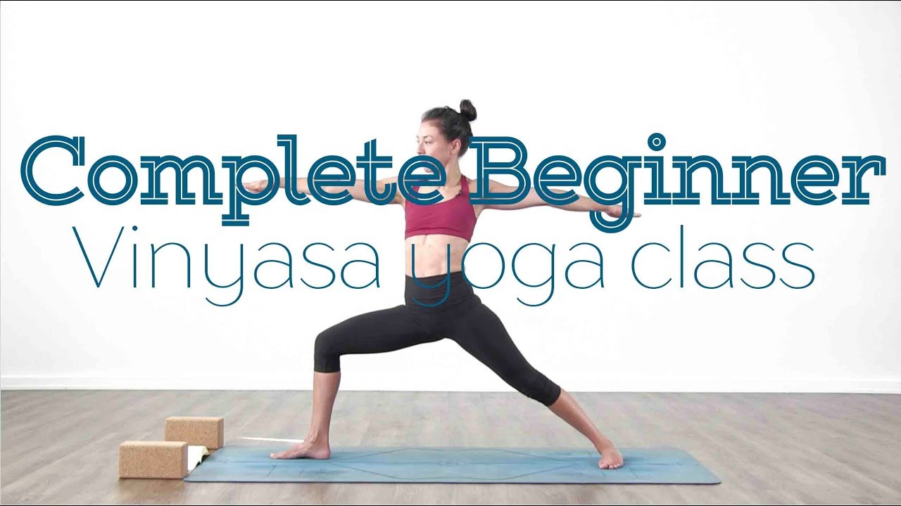 A woman practicing yoga in a warrior pose during a beginner Vinyasa class.